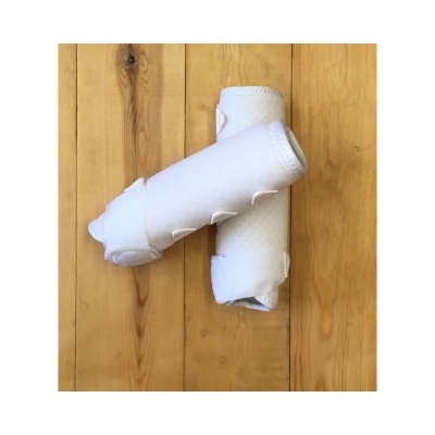 Protetores de pernas brancos com velcro sobre chão de madeira