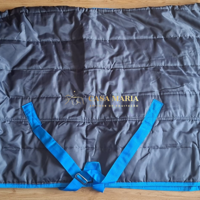 Capa para cavalo cinza escuro com acabamento azul e tiras de ajuste azuis