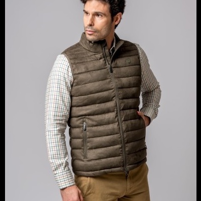Homem com colete acolchoado castanho, camisa xadrez e calças castanhas