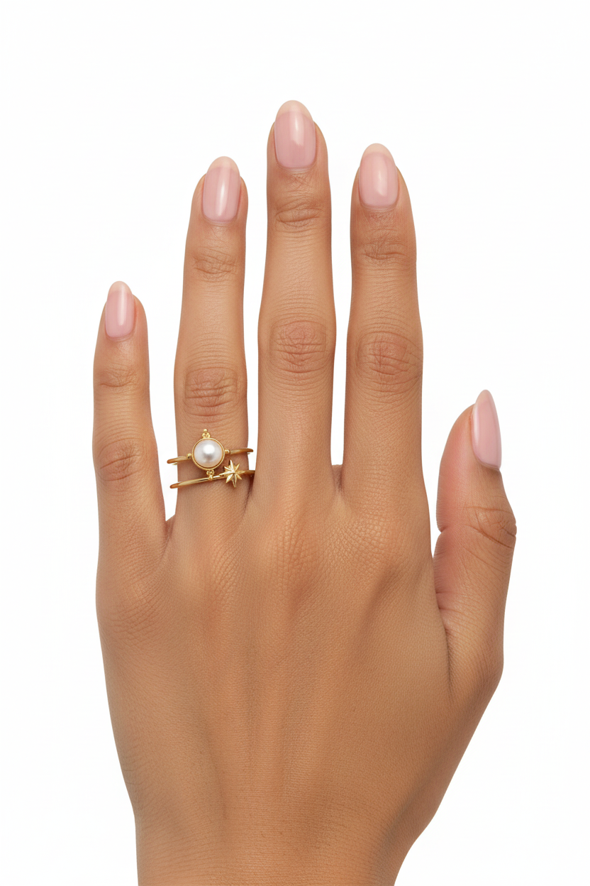Mão feminina com anel dourado com pérola e estrela