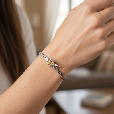 Pulseira prateada com fecho dourado no pulso