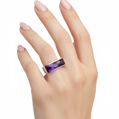 Mão feminina a usar anel largo com pedra roxa facetada