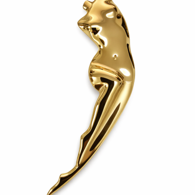 Escultura dourada brilhante de uma figura feminina estilizada sobre fundo branco.