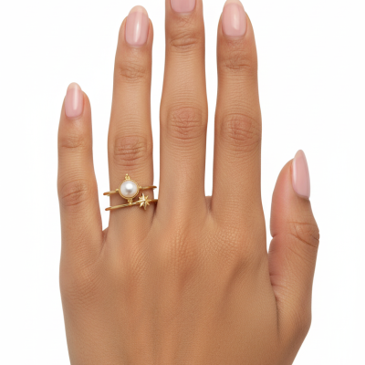 Mão feminina com anel dourado com pérola e estrela