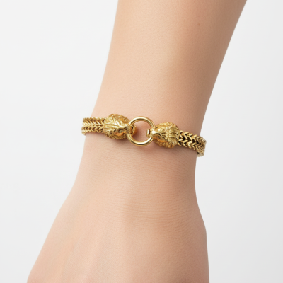 Pulseira dourada com elos e cabeças de animal no fecho usada no pulso