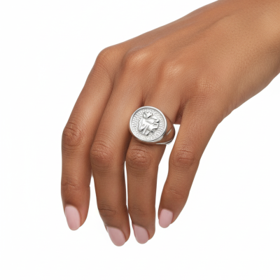 Anel de prata com figura em relevo num dedo de mão de pele morena