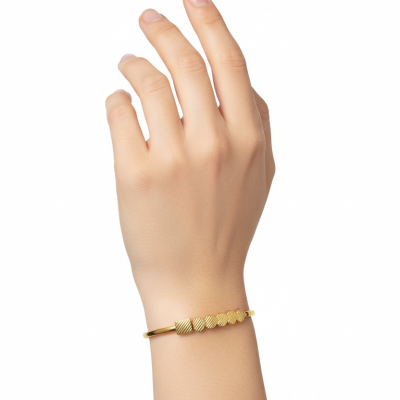 Pulseira dourada fina com detalhes circulares texturizados no pulso