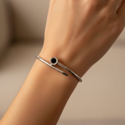 Pulseira prateada com detalhe preto em formato de prego no pulso