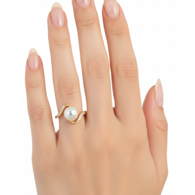 Mão feminina com anel dourado de pérola e pedras pequenas