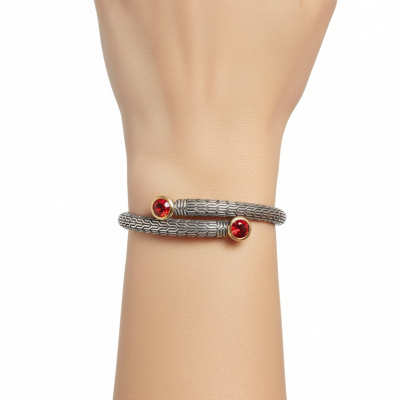 Pulseira prateada com pedras vermelhas em mãos em fundo branco