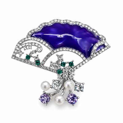 Broche em formato de leque em metal prateado com esmalte azul e pedras decorativas.