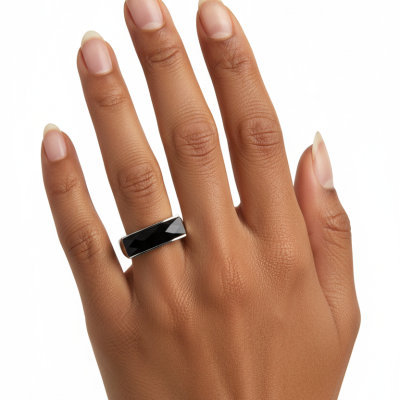 Anel prateado com pedra preta em dedo médio de mão castanha clara