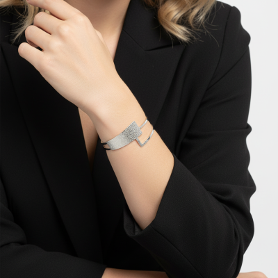 Pulseira prateada texturada usada no pulso de mulher com blazer preto