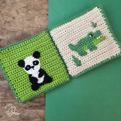 Dois quadrados de croché com figura de panda e crocodilo