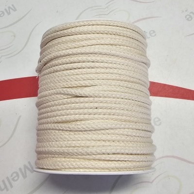 Rolo de cordão grosso creme sobre bobina branca