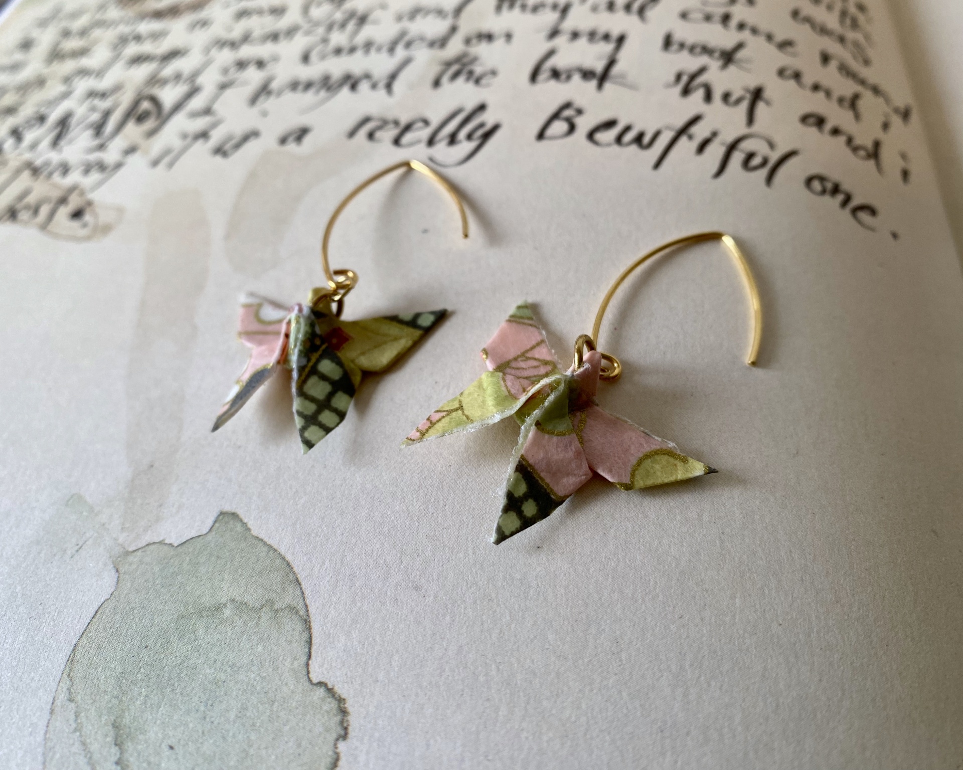 Brincos Borboleta Brincos de gancho dourados com pendentes de borboleta em papel colorido com padrão floral.