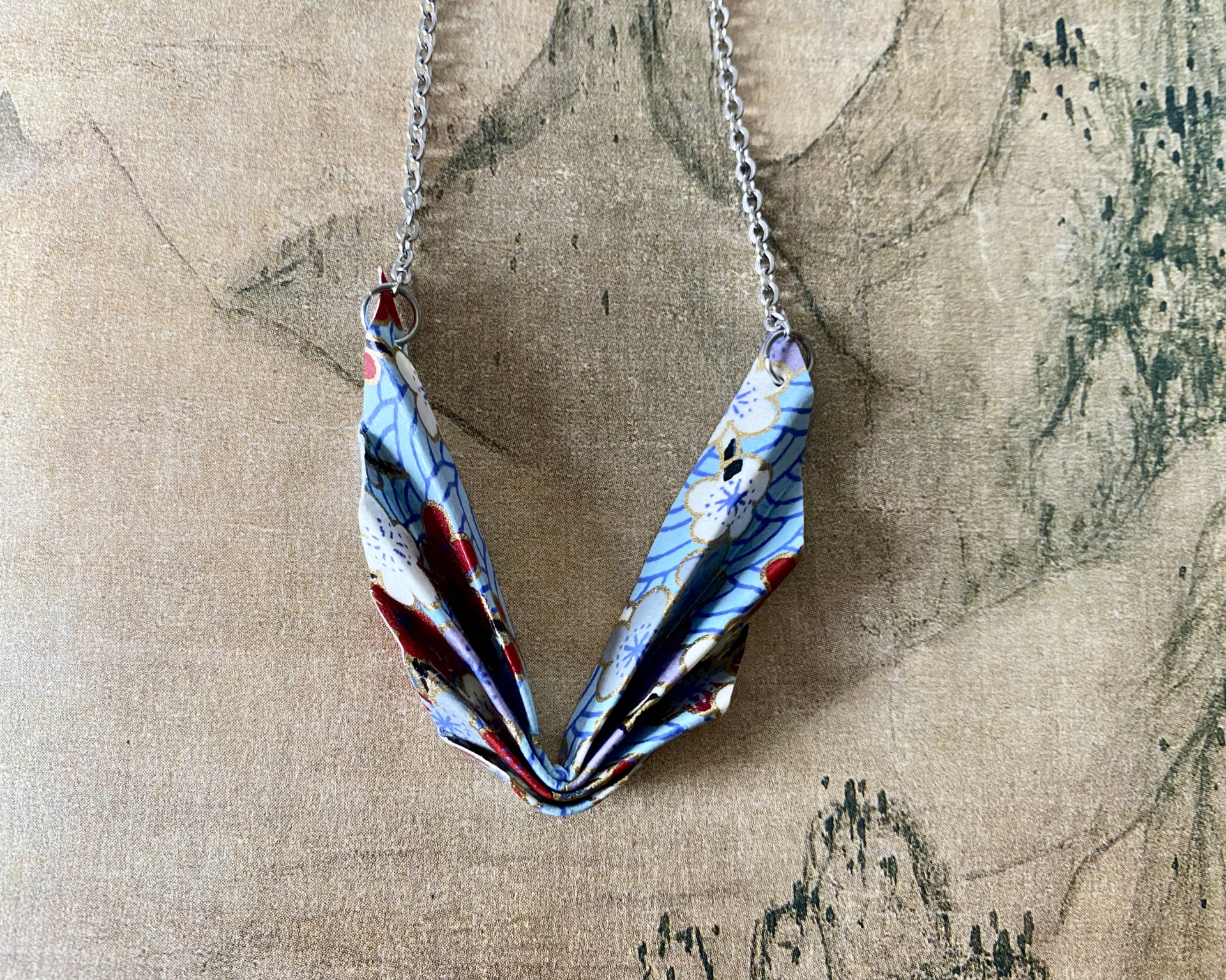 Colar Niki Colar com pingente origami azul com flores em corrente prateada