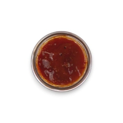 Recipiente redondo com molho vermelho brilhante.