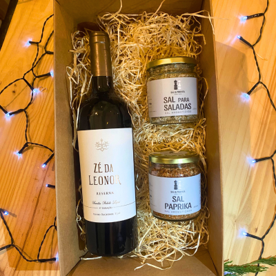 Cesta de presente com vinho e sal aromatizado em caixa de cartão com decoração de luzes azuis.