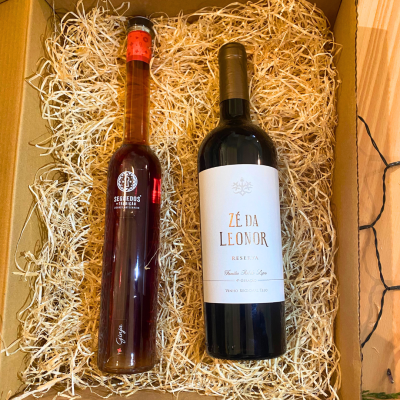 Caixa com duas garrafas, uma de licor e outra de vinho, com embalagens em palha