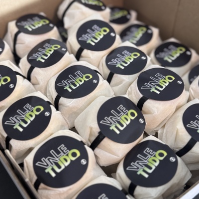 Pacotes embalados com etiqueta VALE TUDO em caixa de cartão