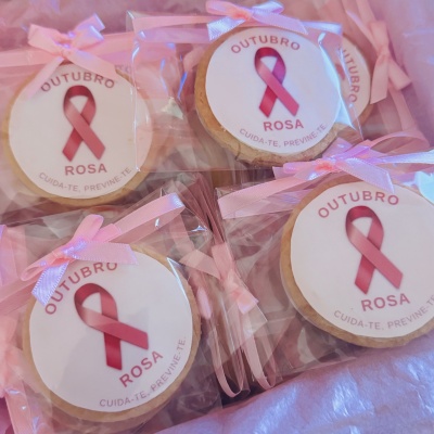 Bolachas redondas decoradas com laço rosa e etiqueta Outubro Rosa em embalagem de plástico