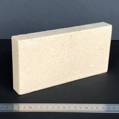 Tijolo retangular bege com régua ao lado para escala