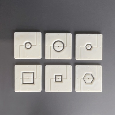 Seis moldes brancos quadrados com diferentes recortes geométricos no centro