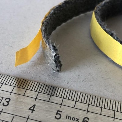 Tiras de vedante pretas com fita adesiva amarela junto a régua de metal