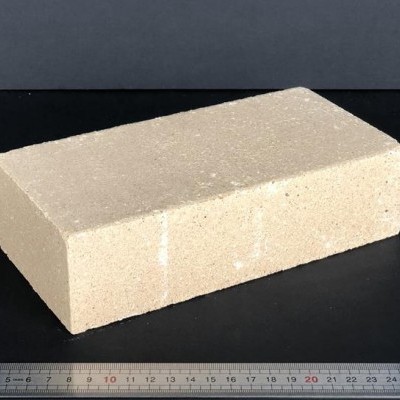 Bloco retangular de cimento bege claro com régua metálica ao lado
