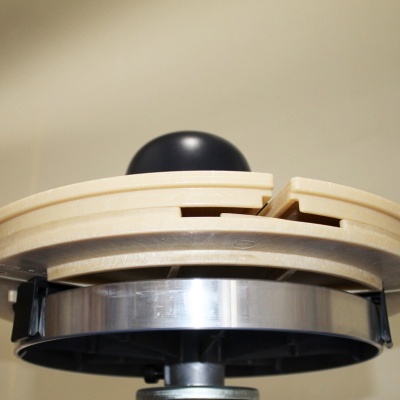 Torreta giratória de madeira clara com metal prateado e bola preta