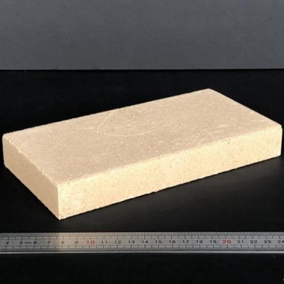 Bloco retangular creme com régua ao lado sobre fundo preto