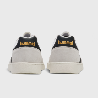 Ténis Hummel cinzento claro e preto vistos da traseira