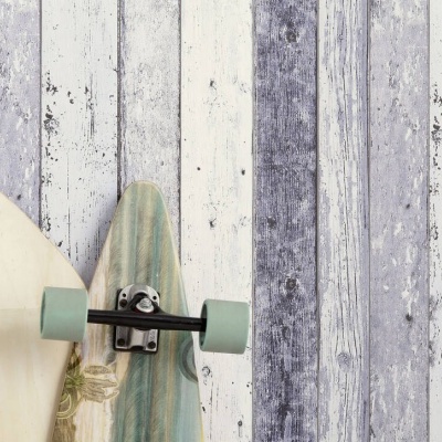 Duas pranchas de skate encostadas em fundo de madeira envelhecida