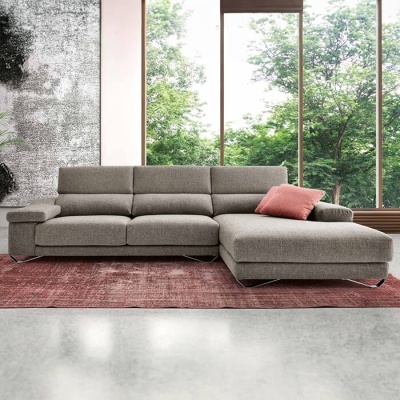 Sofá chaise longue cinza com almofada cor-de-rosa numa sala moderna