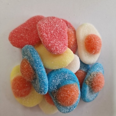 Gomas açucaradas coloridas em formas redondas com centro laranja em fundo branco