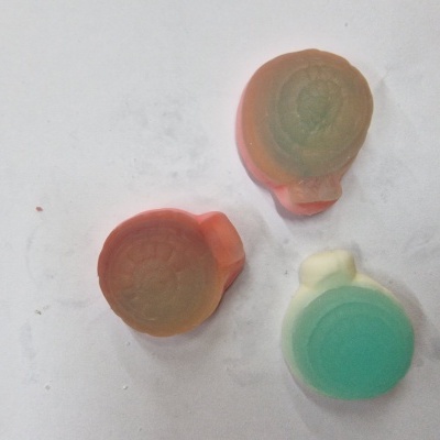 Três pequenos objetos arredondados coloridos sobre fundo branco