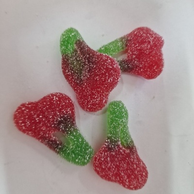 Gomas em forma de cereja com açúcar em superfície branca