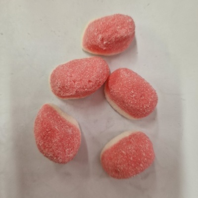 Cinco gomas de doce rosa e branco cobertas de açúcar em fundo branco