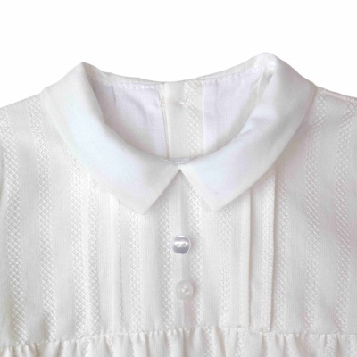 Vestido branco para bebé com gola redonda e botões brancos.