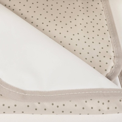 Toalha bege com padrão de pequenos pontos e borda costurada