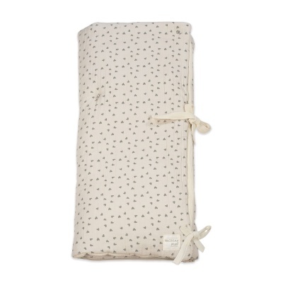 Manta infantil bege com pequenas flores cinzentas e fitas para amarrar