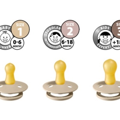 Três chupetas de silicone amarelo com bases cinza em diferentes tamanhos e indicações de idade.