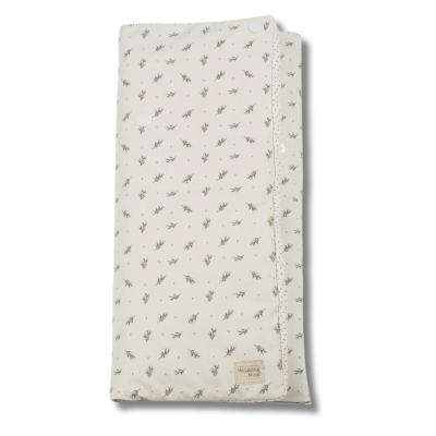 Manta bege com padrão de flores pequenas e botão branco