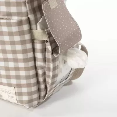 Mochila bege e branca com padrão xadrez e bolso lateral aberto