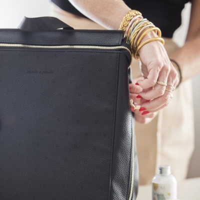 Mala preta em pele texturada com padrão de estrelas e acessórios de higiene