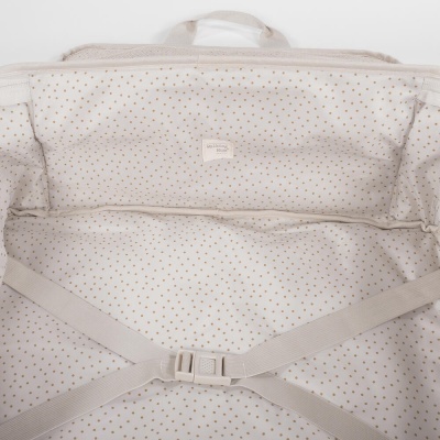 Interior de mala clara com padrão de pequenos pontos dourados e alças cruzadas ajustáveis