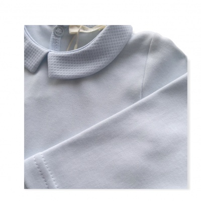 Peça de roupa infantil branca com gola arredondada e textura