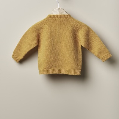 Camisola de criança mostarda em malha pendurada num cabide