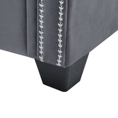 Detalhe pé móvel estofado cinza com tachas metálicas.